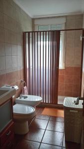 a bathroom with a toilet and a sink and a tub at Casa Maricarmen in Camariñas +12 photos