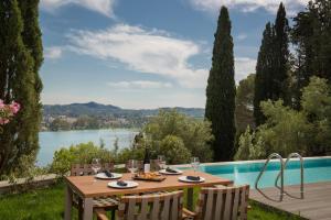 a table with wine glasses on it next to a pool at Rodostamo Hotel & Spa- Adults Friendly in Kommeno