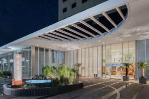 リベイラン・プレトにあるIntercity Ribeirão Pretoのヤシの木が前に生えている大きな建物