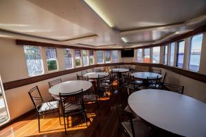 a dining room with tables and chairs and windows at Tapri - Hotel Flutuante in Barra Bonita