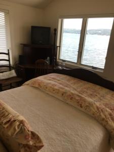 a bedroom with a bed with a large window at Chateau du Lac in Richfield Springs