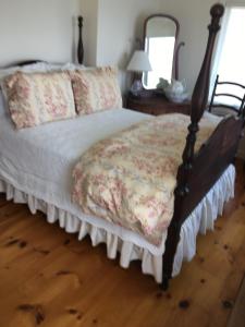 a bedroom with a bed with a wooden floor at Chateau du Lac in Richfield Springs