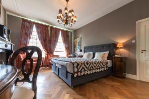 um quarto com uma cama, uma mesa e janelas em B&B De Schiedamse Suites em Schiedam