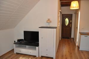 salon z telewizorem na białej szafce w obiekcie Apartament pod Dębem w mieście Bobolice +22 zdjęcia