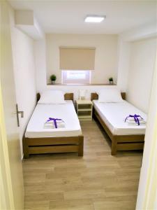 2 camas en una habitación con una cruz en la pared en Villa Gaj, en Novalja