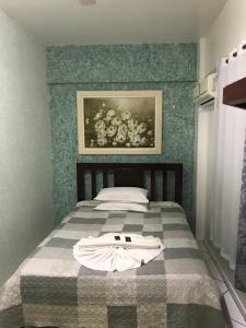1 dormitorio con 1 cama con una pintura en la pared en Hotel Zagonel, en Chapecó