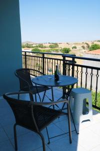 a table and chairs on a balcony with a view at Fergani Apartments in Moúdhros