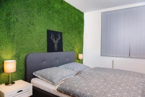 um quarto com uma cama e uma parede verde em Nexus Apartmenthotel em Hévíz