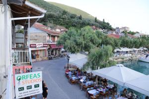 a street with tables and chairs in a town at Orfeas Studios in Vasiliki