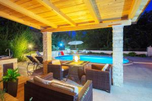 a patio with chairs and a swimming pool at night at Holiday Home Villa Lucia in Vodnjan