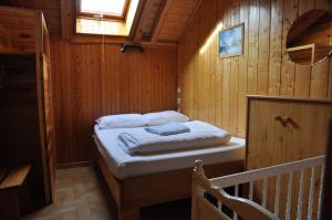 ヴァロワールにあるGîte les Réauxの木製の部屋にベッド1台が備わるベッドルーム1室があります。