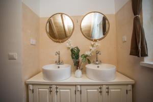 a bathroom with two sinks and two mirrors at Captain's Attic in Račišće