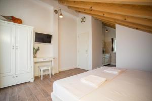 a bedroom with a white bed and a desk at Captain's Attic in Račišće