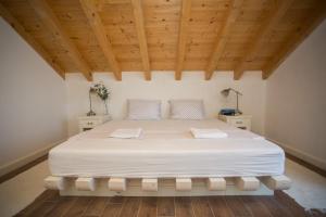 a large white bed in a room with wooden ceilings at Captain's Attic in Račišće