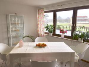 Biały stół z miską owoców w pokoju z oknami w obiekcie Rennbahn - Life Iffezheim; Wohnen mit Rennbahnblick w mieście Iffezheim