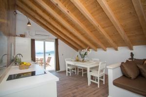 a kitchen and living room with a table and a couch at Captain's Attic in Račišće