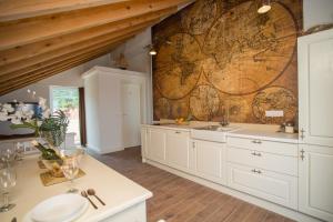 a kitchen with white cabinets and a map on the wall at Captain's Attic in Račišće