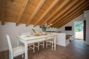 a kitchen with a white table and chairs and wooden ceilings at Captain's Attic in Račišće
