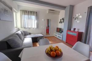 uma sala de estar com uma mesa com uma taça de fruta em Apartman Pula em Pula