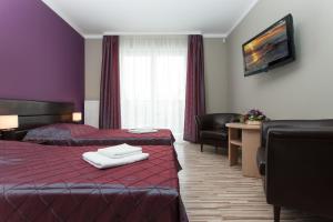 a hotel room with two beds and a table and chairs at NA BIAŁEJ in Rewal