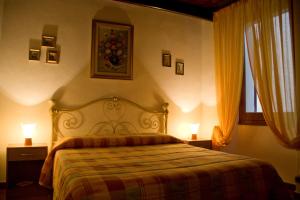 sypialnia z łóżkiem z 2 lampami i oknem w obiekcie B&B Vecchia Alghero w mieście Alghero