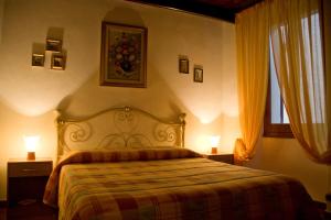 1 dormitorio con 1 cama con 2 lámparas y una ventana en B&B Vecchia Alghero, en Alghero