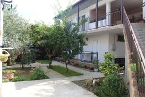 a courtyard of a house with trees and plants at Guest House U Aleny in Gagra
