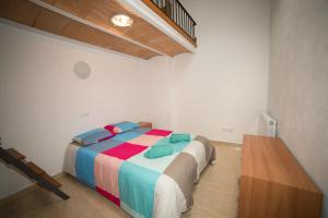 Un dormitorio con una cama con almohadas de colores. en Casa Julia Graus, en Graus