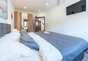 Un dormitorio con una cama grande con un televisor en la pared. en Apartments Villa Elena 2, en Cavtat 20 fotos más