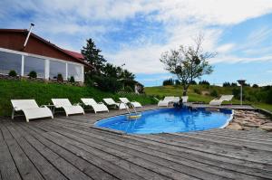 una piscina con sillas blancas en Okrągłe Resort SKI & SAFARI, en Orzysz