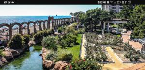 un jardín junto al agua con un puente en ACAPULCO III MARINA DÓR, en Oropesa del Mar