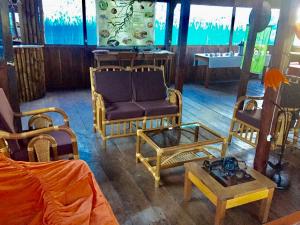 Yaku Amazon Lodge & Expeditions في Paraíso: غرفة معيشة مع كرسيين وطاولة