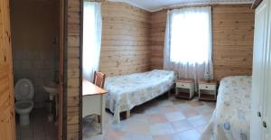 a small room with two beds and a toilet at Hiiden Kämppäkartano iso vuokramökki lähellä Tiilikan kansallispuistoa in Sotkamo