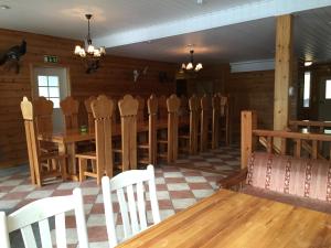 a dining room with wooden chairs and a long table at Hiiden Kämppäkartano iso vuokramökki lähellä Tiilikan kansallispuistoa in Sotkamo