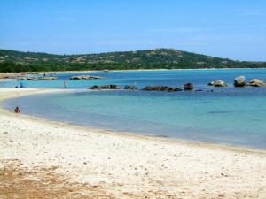 einen Sandstrand mit Felsen im Wasser in der Unterkunft Mora Dell Onda in Porto-Vecchio