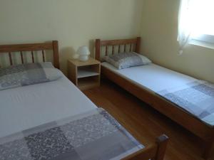 dwa łóżka pojedyncze w pokoju z oknem w obiekcie Apartment Bucic w mieście Vir
