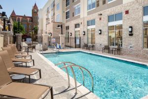 a swimming pool with tables and chairs next to a building at Hyatt Place Sumter/Downtown in Sumter