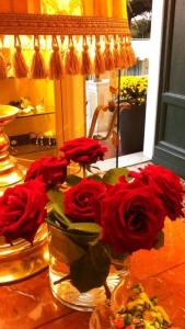 阿倫扎諾的住宿－埃納酒店，一组红玫瑰花在桌子上的花瓶里