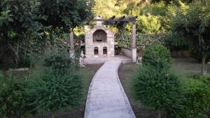 a path leading to a small building in a garden at Apartments Ivo Bozinovic in Tivat