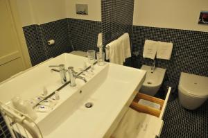 a bathroom with a sink and a toilet at Archivio dei Ricordi - Casa con vista a Ostuni in Ostuni +13 photos