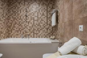 ein Badezimmer mit einer Badewanne, einem WC und einem Waschbecken in der Unterkunft Hotel A Roldana in Narón