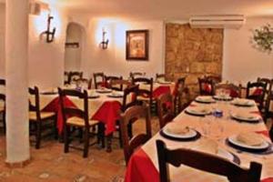 a dining room with tables and chairs with red table cloth at Hotel Zahorí in Priego de Córdoba