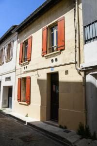 a building with orange shuttered windows on a street at Le Sureau in Avignon