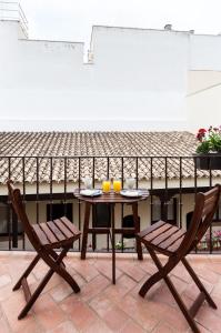セビリアにあるApartamento Dúplex en la Alameda de Sevillaのテーブル(椅子2脚付)とオレンジジュース2杯