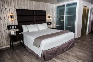 a bedroom with a large bed with a large headboard at Plaza Paitilla Inn in Panama City