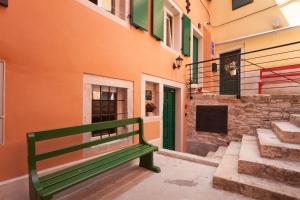 zielona ławka siedząca przed budynkiem w obiekcie Apartments and Rooms Hey Rovinj w Rovinj