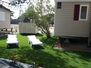 カネ・アン・ルシヨンにあるMobil home 3 chambresの芝生の椅子2脚と家のある庭
