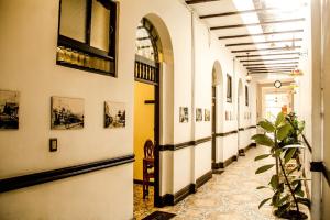 a hallway of a building with pictures on the walls at Epoca Iquitos in Iquitos