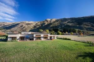 uma casa num campo com montanhas ao fundo em Horizons em Wanaka