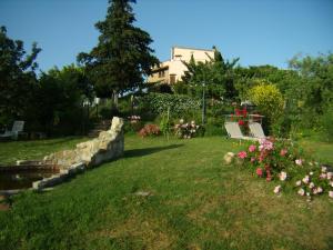a park with a bench and flowers in the grass at Nido di Rondine in Montespertoli